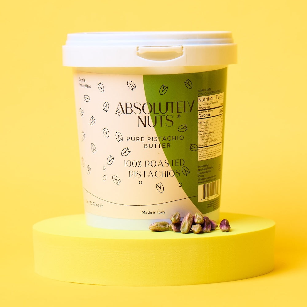 Container of Absolutely Nuts pistachio butter on a yellow background
