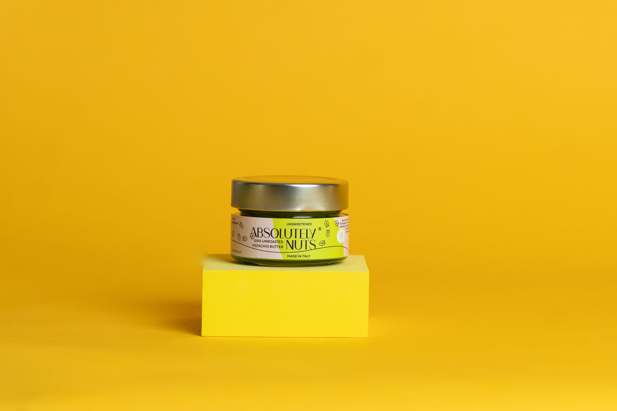Jar of 'Absolutely Nuts' on a yellow cube with a yellow background