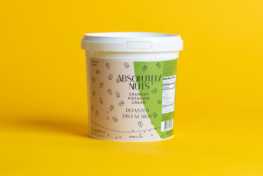Container of Absolutely Nuts Crunchy Pistachio Creme on a yellow background