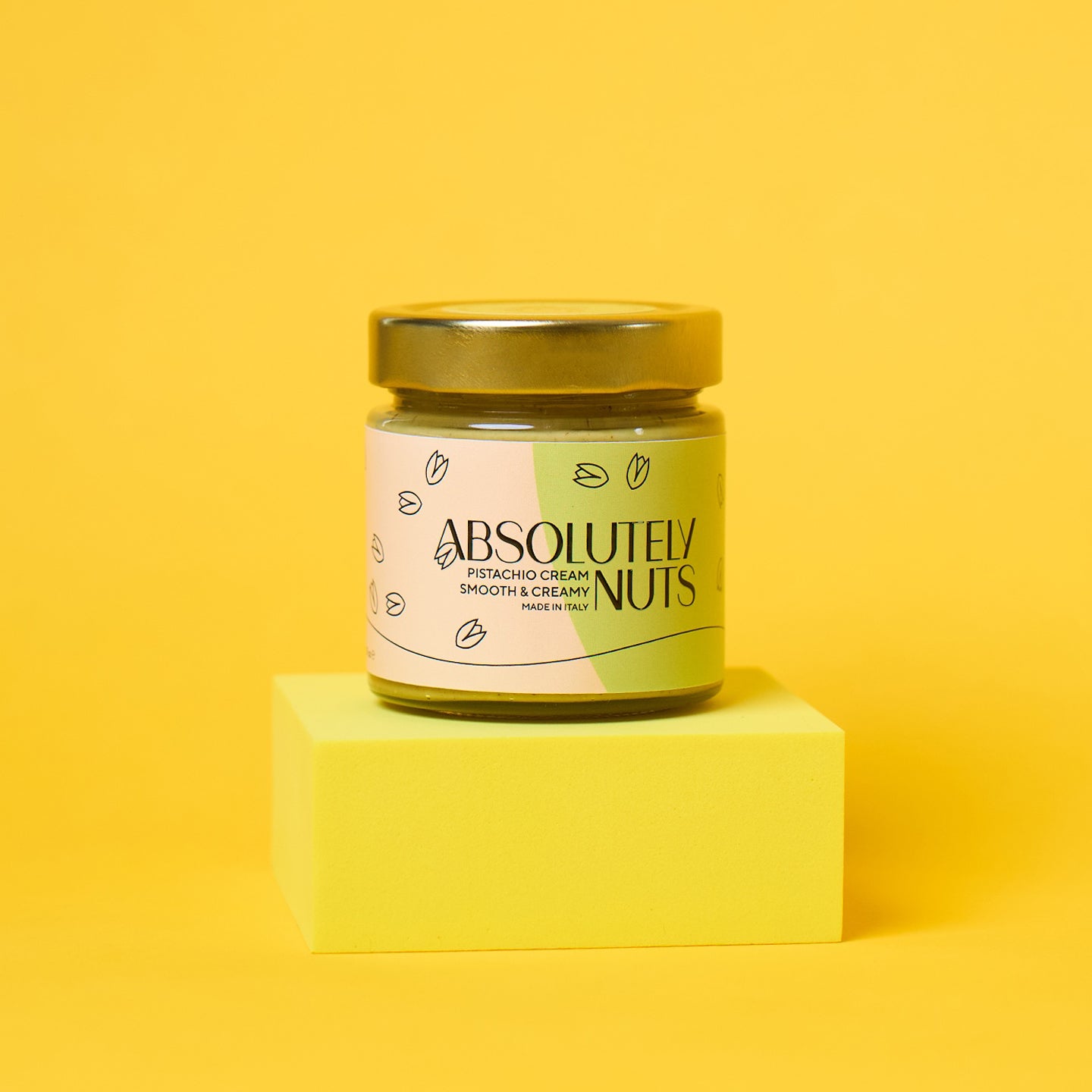 Jar of 'Absolutely Nuts' pistachio cream on a yellow background