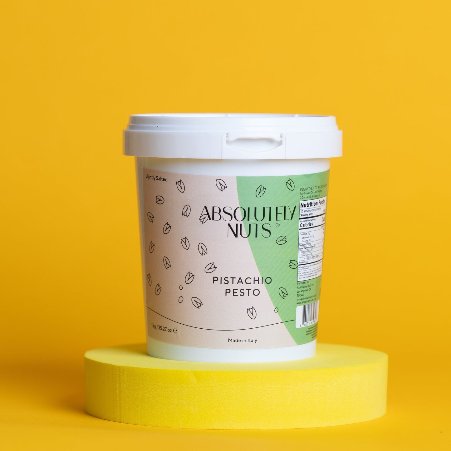 Container of 'Absolutely Nuts' Pistachio Pesto on a yellow background