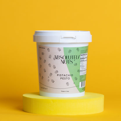 Container of 'Absolutely Nuts' Pistachio Pesto on a yellow background