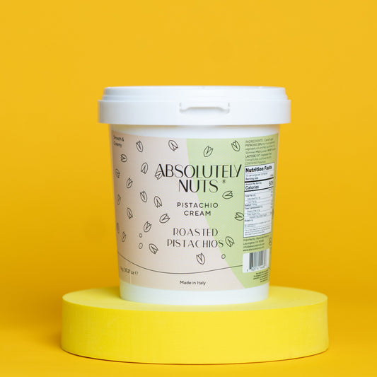 Container of Absolutely Nuts roasted pistachios on a yellow background